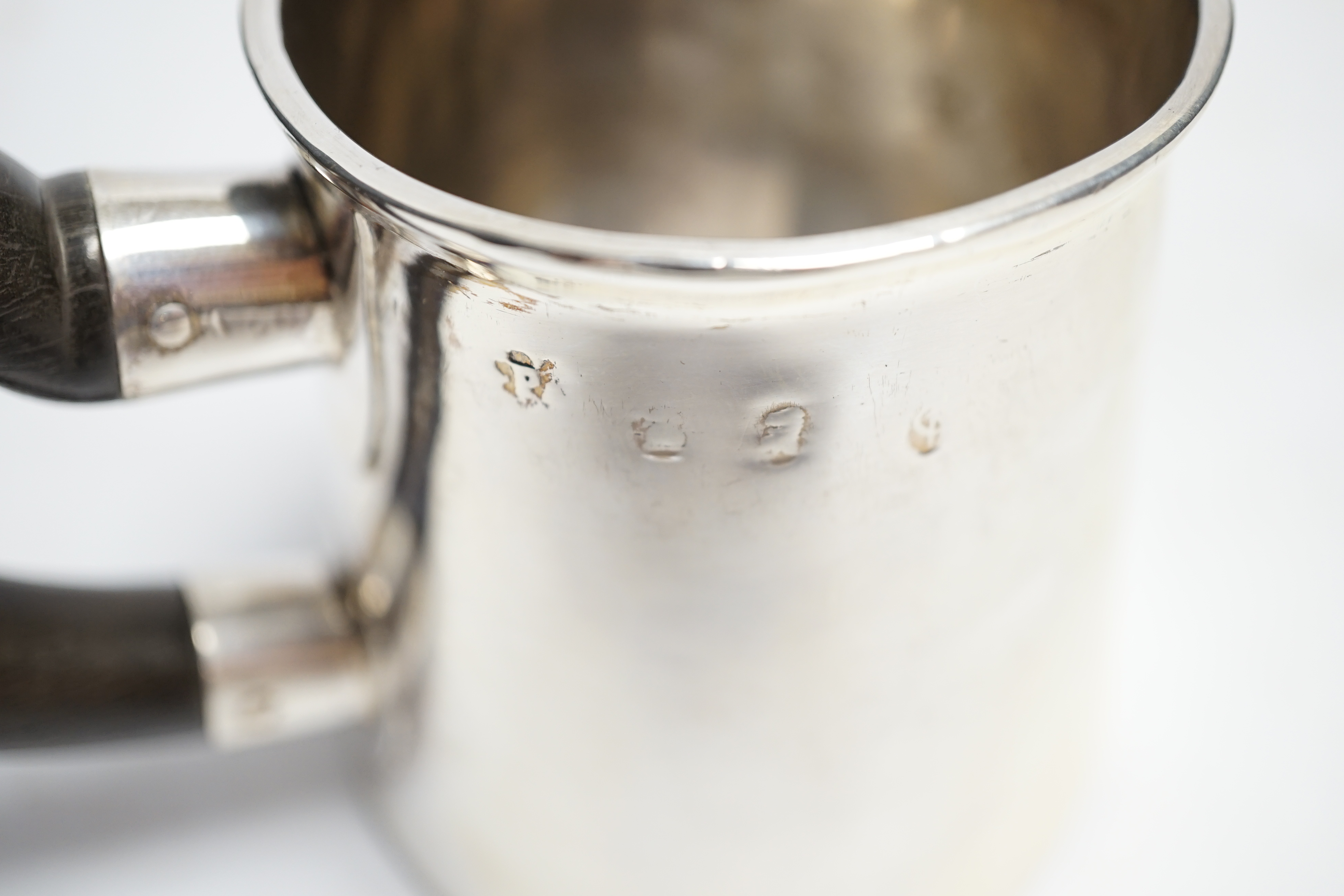 An early 18th century silver mug, with wooden handle, marks rubbed, height 78mm. Condition - poor